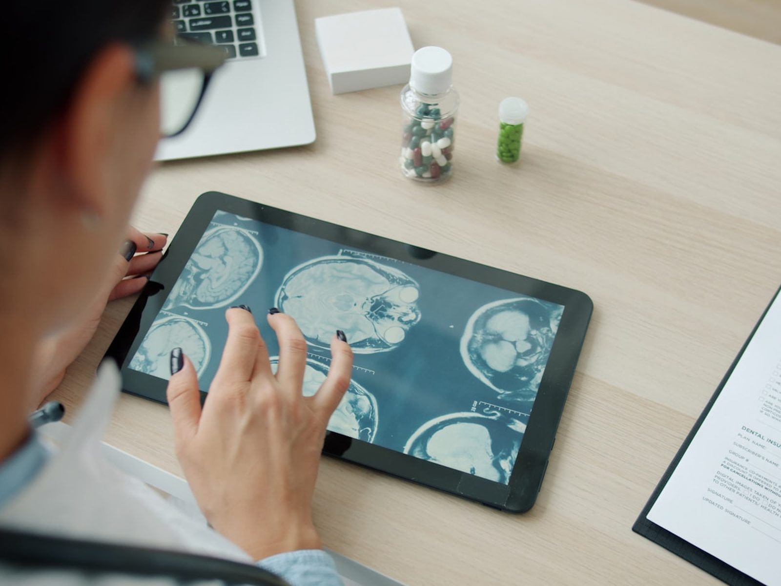 Physician reviewing an MRI scan on a tablet in a clinical office.