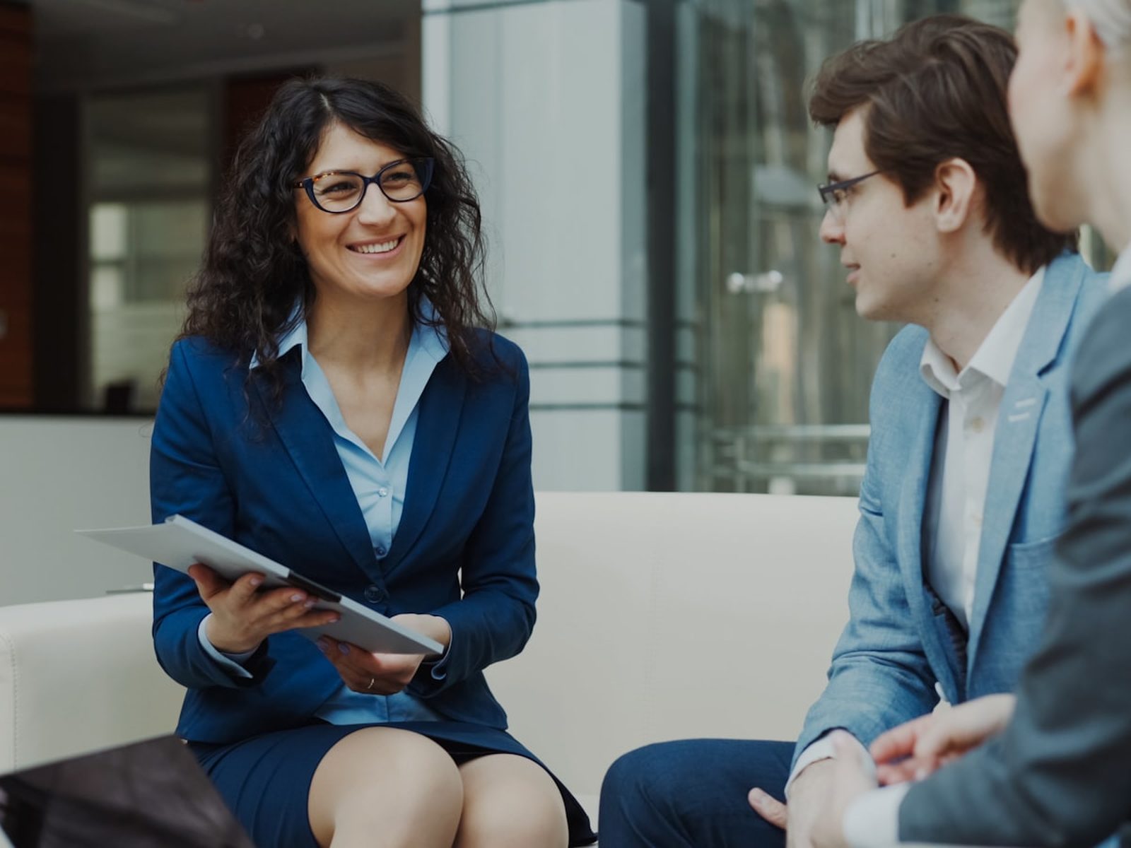 Three professionals collaborating around a table in a modern office.